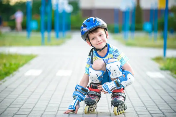 Photo of Smiling boy with inline skates and protective gear
