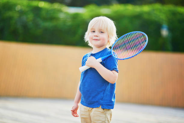 istock Little boy playing badminton on the playground 972858318