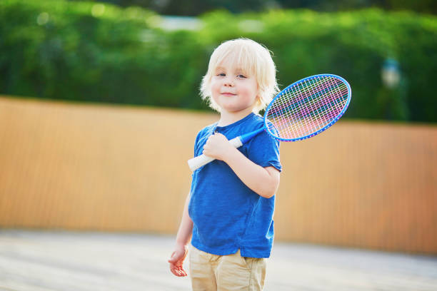 menino jogando badminton no playground - racquette - fotografias e filmes do acervo