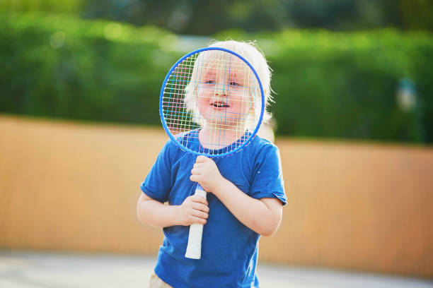 menino jogando badminton no playground - racquette - fotografias e filmes do acervo