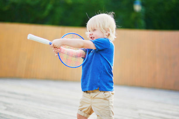 menino jogando badminton no playground - racquette - fotografias e filmes do acervo