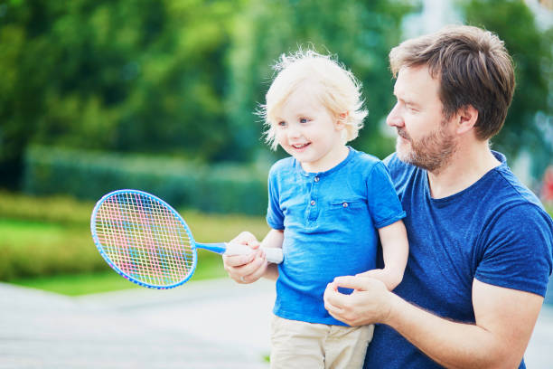 menino jogando badminton com o pai no playground - racquette - fotografias e filmes do acervo