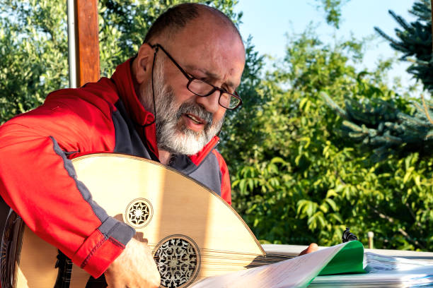 Senior Man Musician playing Oude / Lute and He is singing