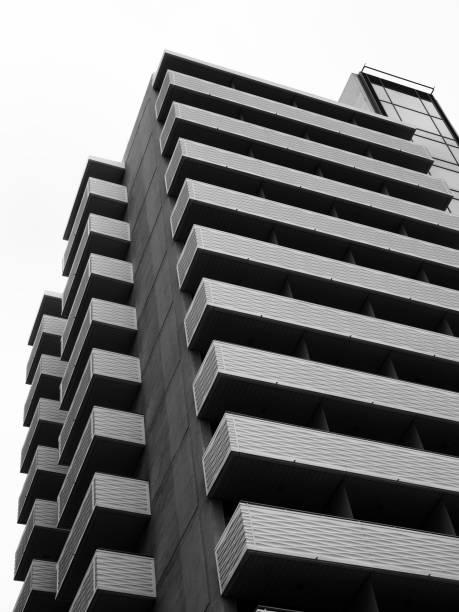 istock large modern apartment block with external balconies in horizontal pattern with concrete sides and white sky in monochrome 972872764