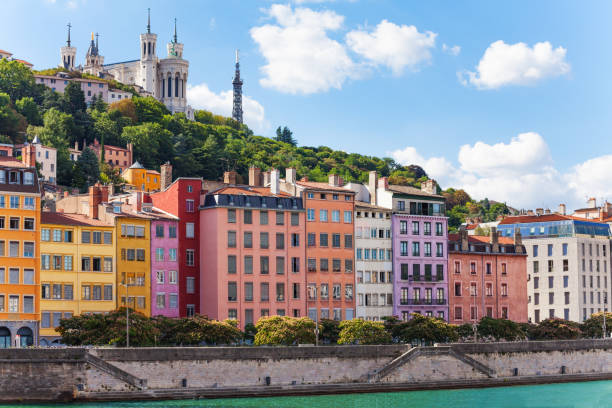 Color houses at the Saone river bank, Lyon, France Scenic view of St. Georges district of old Lyon with its color houses and Basilica of Notre-Dame de Fourviere on the background embankment photos stock pictures, royalty-free photos & images