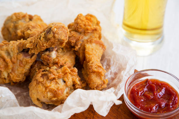 istock Fried chicken legs with sauce and cold beer, close-up. 972874014