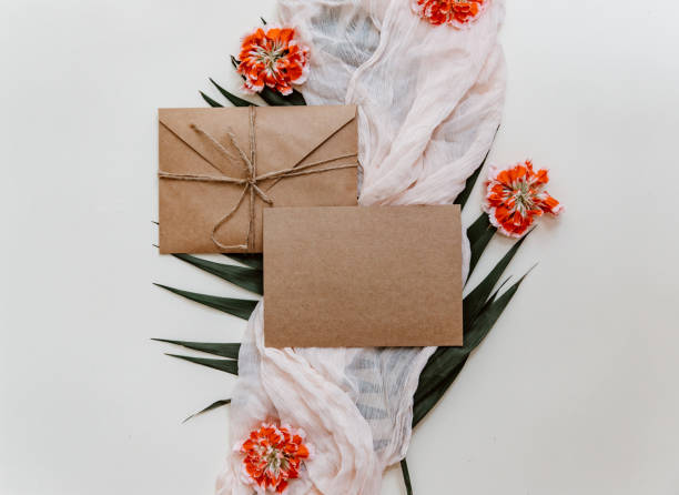 istock Wedding invitation card. Greetings card with craft envelope and flowers flat lay 972880310