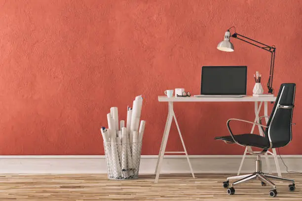 Workdesk with decoration on hardwood floor in front of empty red wall with copy space. 3D rendered image.