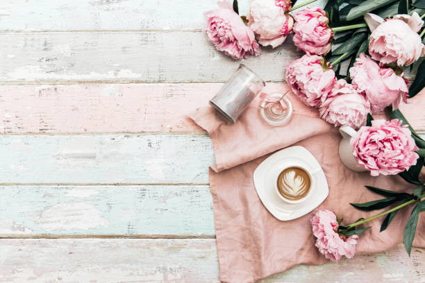 牡丹の花とぼろぼろのシックな背景の上にコーヒー カップ。トップ ビュー - イヤリング 写真 ストックフォトと画像