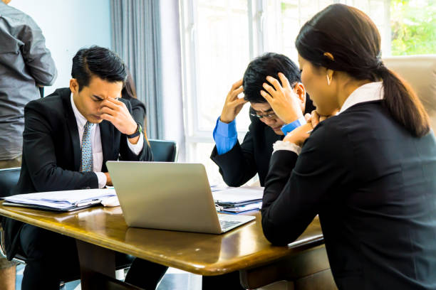 istock Depressed Business Colleagues Sitting At Table In Office 972886004