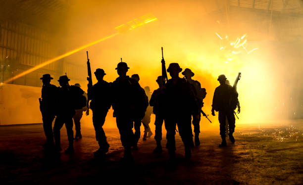 istock Silhouette Soldiers Walking On Field At Night 972889162