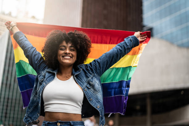 Woman Waving Rainbow Flag at Gay Parade Freedom - LGBT Concept lgbtqia culture photos stock pictures, royalty-free photos & images