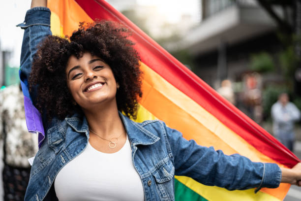 Woman Waving Rainbow Flag at Gay Parade Freedom - LGBT Concept gay pride parade photos stock pictures, royalty-free photos & images
