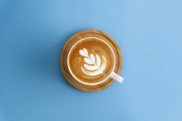 istock Coffee cup with wooden plate on blue color background. 972908244