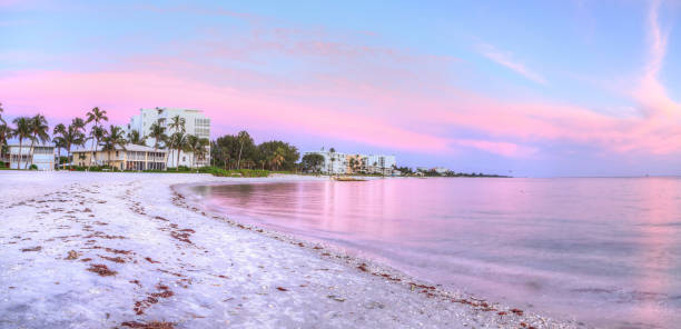 pôr do sol lowdermilk beach sobre a areia branca - florida naples florida beach sunset - fotografias e filmes do acervo