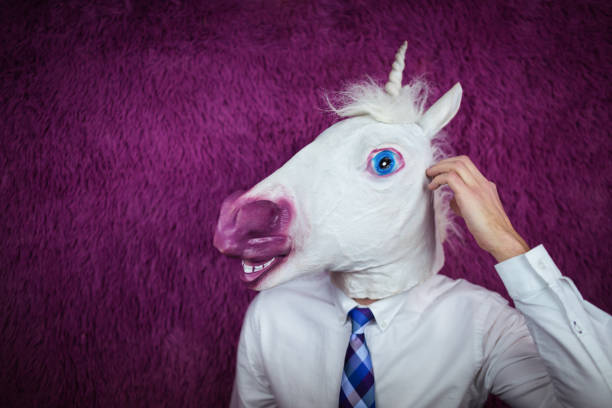freaky jeune homme au masque de comique se dresse sur le fond violet - opposition party photos et images de collection