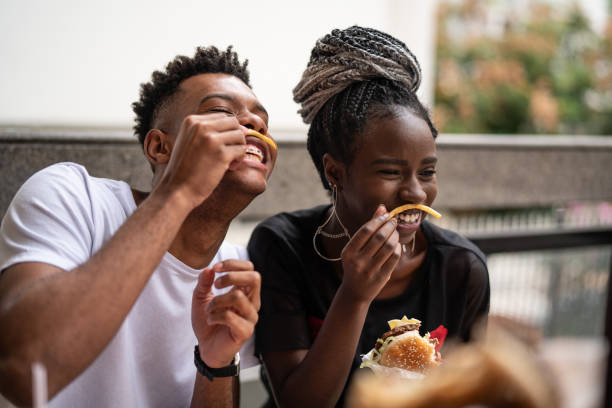 groupe de jeunes s’amuser dans un restaurant - cuisine rapide photos et images de collection