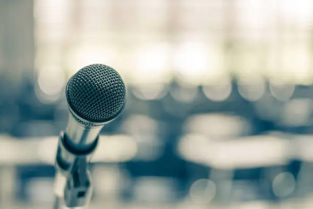 Photo of Microphone voice speaker in school lecture hall, seminar meeting room or educational business conference event for host, teacher or coaching mentor