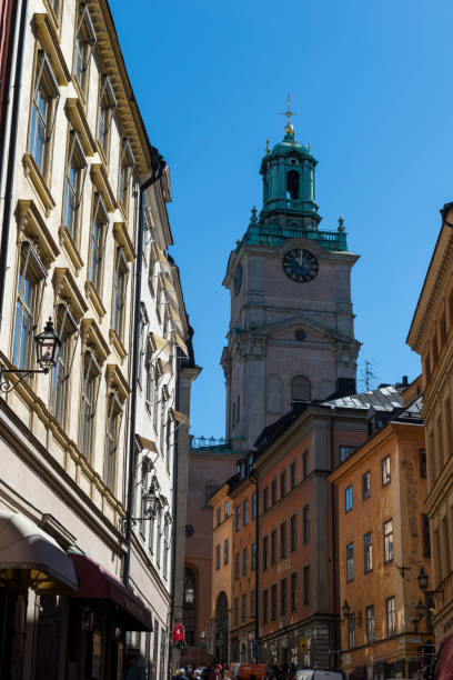 Stockholm, Sweden - June 04, 2015: View of people, buildings and the tower of the church Sankt Nikolai kyrka (Church of St. Nicholas) on the streets of the old town in Stockholm, Sweden