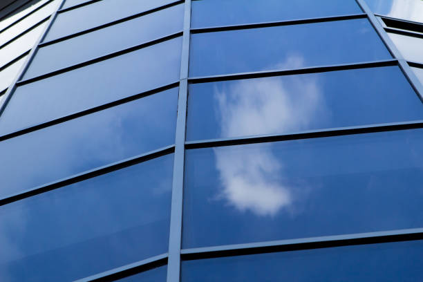 istock Sky reflected in a modern building blue glass facade 972921990