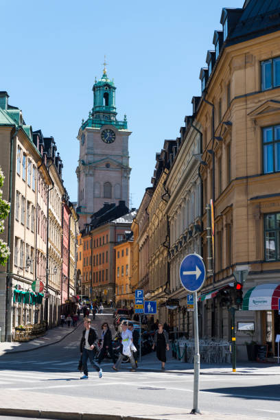 Stockholm, Sweden - June 04, 2015: View of people, buildings and the tower of the church Sankt Nikolai kyrka (Church of St. Nicholas) on the streets of the old town in Stockholm, Sweden