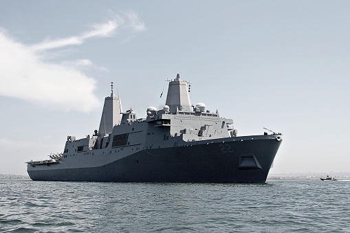 The USS Somerset (LPD-25) looms over a Naval Special Warfare boat in the San Diego Bay.
