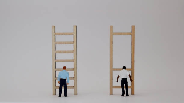 Racist concepts in employment and promotion. Miniature people and miniature wooden ladders. stock photo