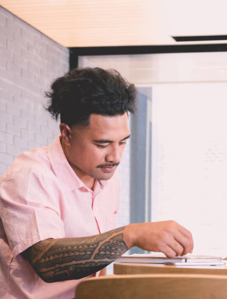 istock Samoan pacific islander male studying a document - could be a student, business employee, applying for a loan or job 973004164