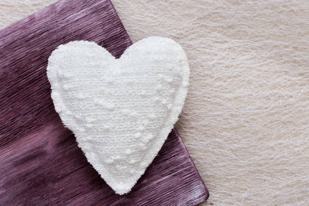 Picture of beautiful handmade white heart on vintage wooden background, soft heart toy. Horizontal format. Top view. Cute present. Love concept.