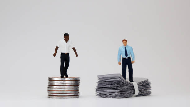The concept of racial wage discrimination in a company. Money and two miniature men. stock photo