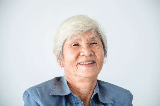 senior female with white color hair smiling at camera stock photo