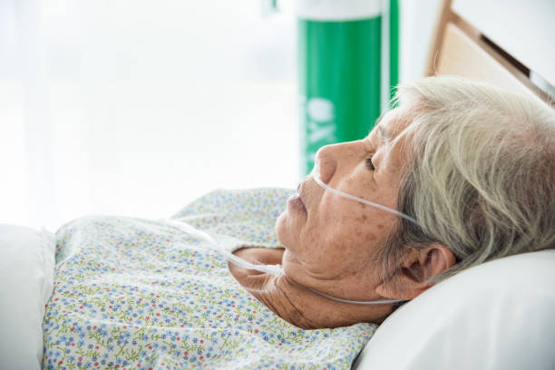 senior female patient sleeping on bed stock photo
