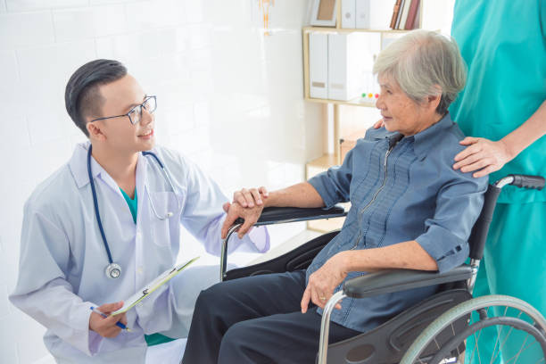 doctor touching patient hand and smiles at hospital stock photo