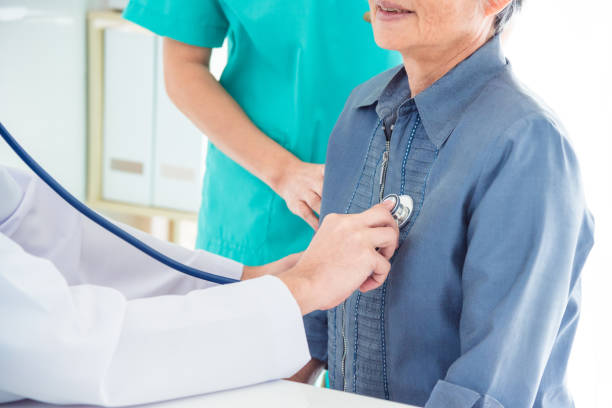 Doctor checking patient's heartbeat by stethoscope stock photo