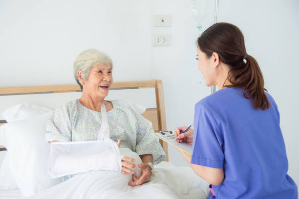 Senior female patient smiling with nurse stock photo