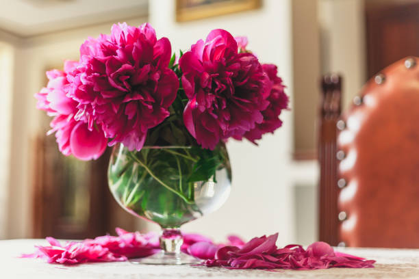 istock red peonies in glass vase stand on table 973053588