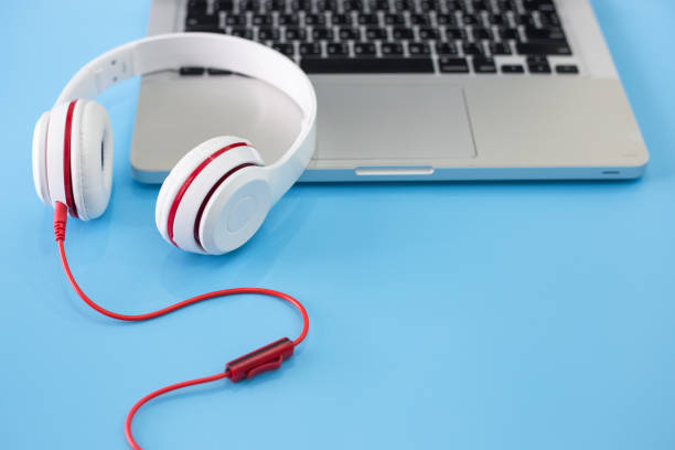 istock white headphones and laptop on blue background. 973070416