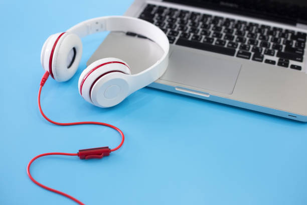 istock white headphones and laptop on blue background. 973070418