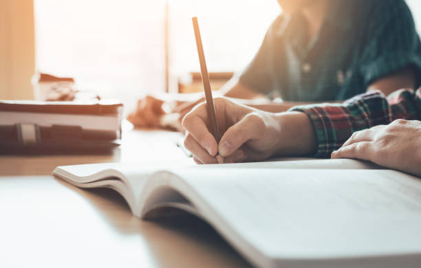 istock Student is studying paper and writing test in modern classroom. 973074714