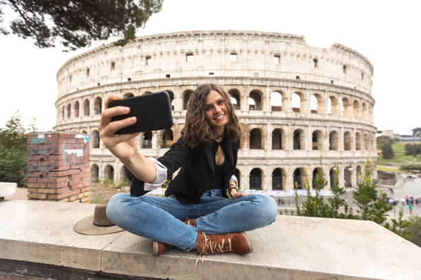 souriant touristique prenant selfie devant le colisée - international landmark italy amphitheater ancient photos et images de collection