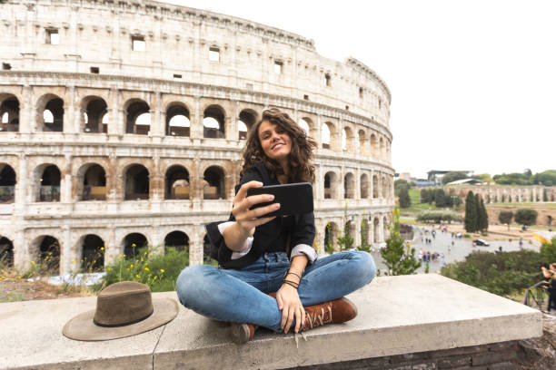 photo de femme souriant messagerie en face du colisée - international landmark italy amphitheater ancient photos et images de collection