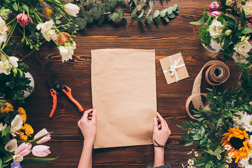 cropped image of florist holding empty sheet of paper in hands
