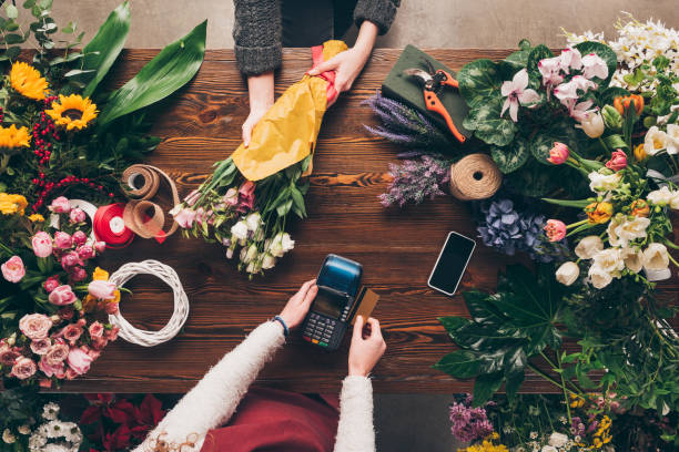 bild des kunden, die zahlung mit kreditkarte für blumenstrauß abgeschnitten - blumenhändler stock-fotos und bilder