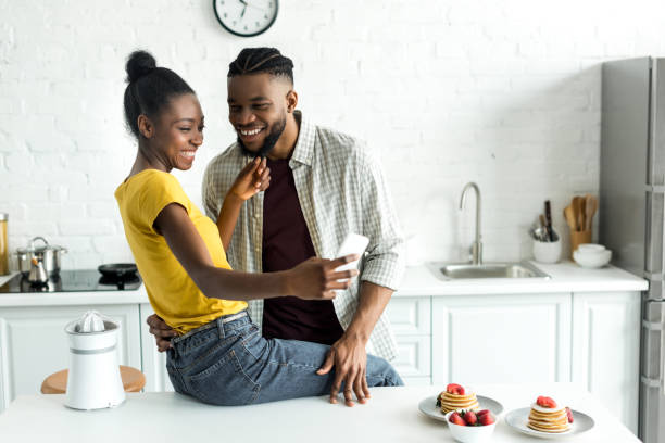istock african american couple taking selfie with smartphone at kitchen 973089504
