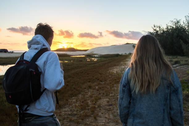 grupa przyjaciół wędrówki po wydmach o wschodzie słońca - sunrise beach couple hiking zdjęcia i obrazy z banku zdjęć