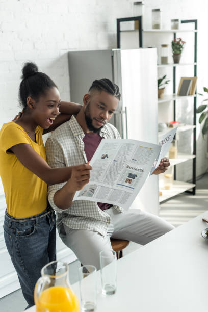 istock african american couple reading newspaper at kitchen 973092088