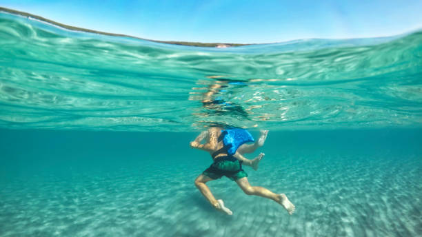istock Father and son swimming in sea 973092548