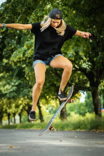 istock girl in a cap performs a skateboard trick 973093074