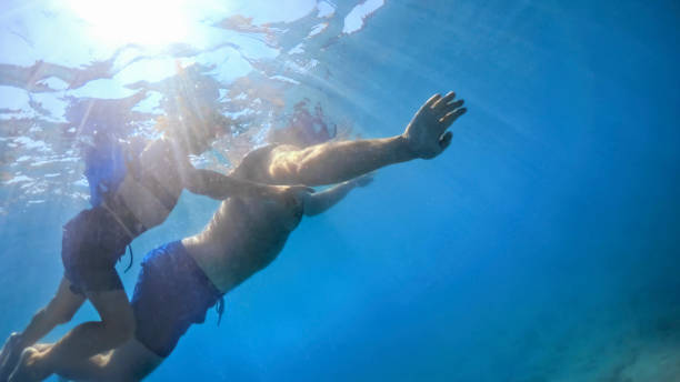 istock Father and son swimming in sea 973093242