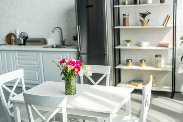 istock interior of modern light kitchen with bouquet on wooden table 973093330
